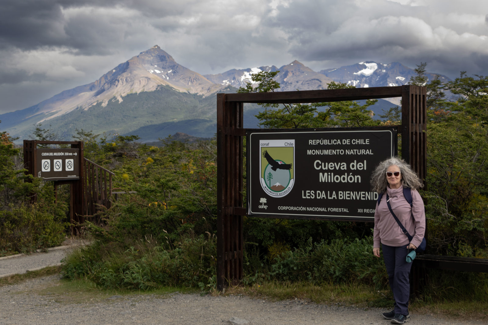 Entrance sign for Cueva del Milodón Natural Monument near Puerto Natales, with Patagonian mountains in the background