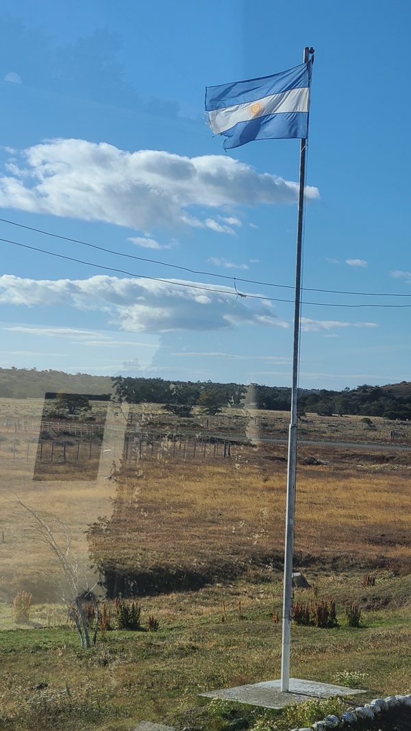 Argentine flag flying beside the road after crossing the Chile–Argentina border in Patagonia.
