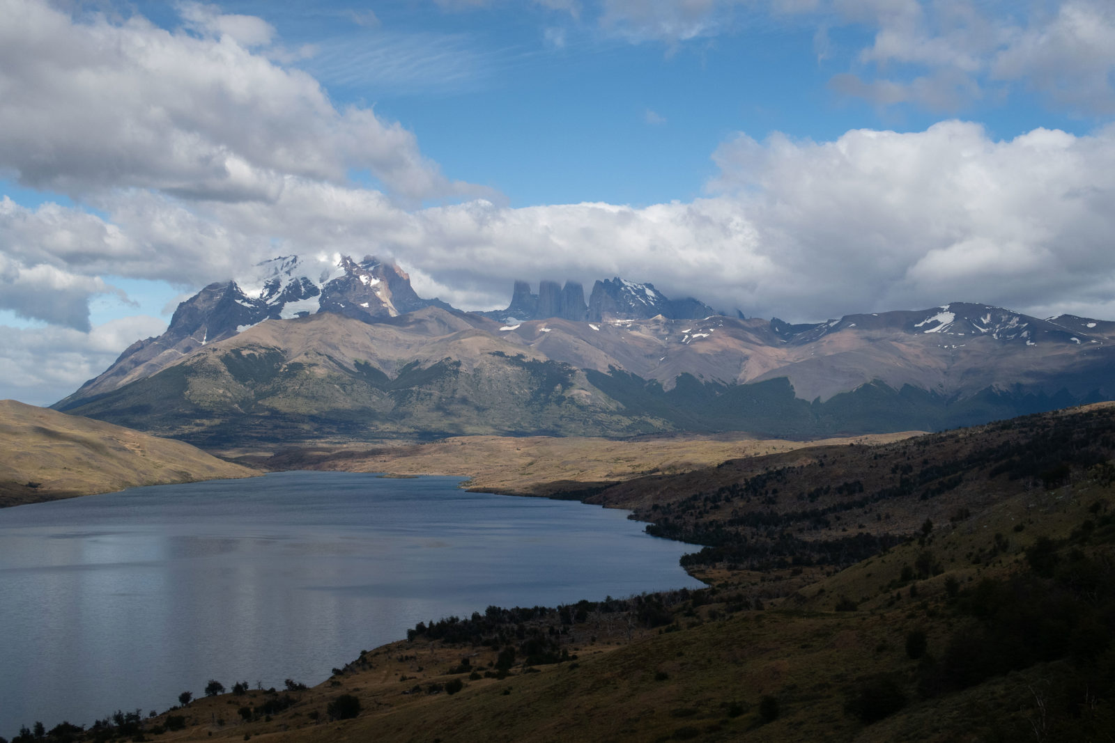 Wide view across Laguna Azul towards the Torres del Paine massif and distant towers in Torres del Paine National Park, Chile.