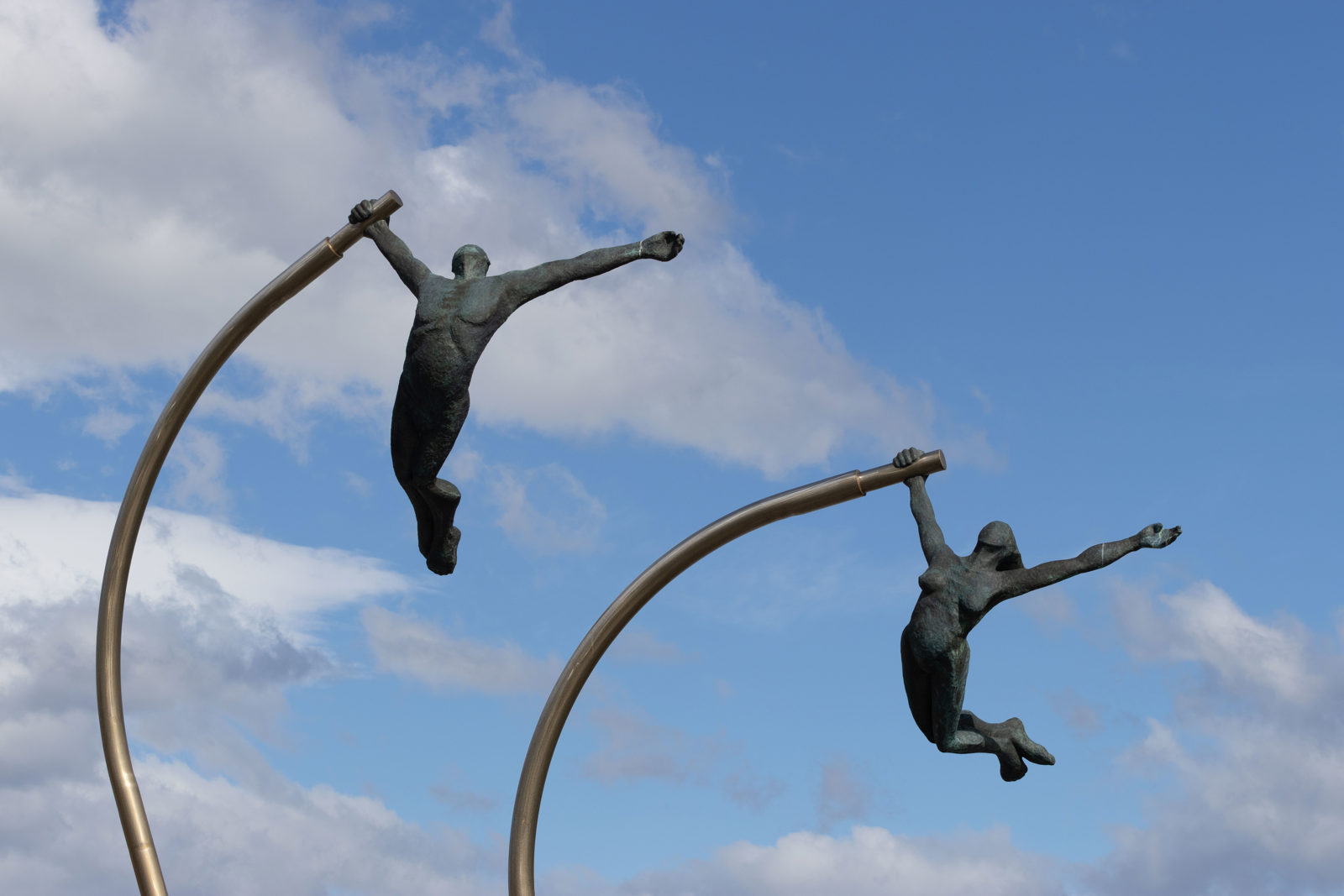Monument to the Wind sculpture on the waterfront in Puerto Natales, Chile, beneath blue skies and passing clouds.