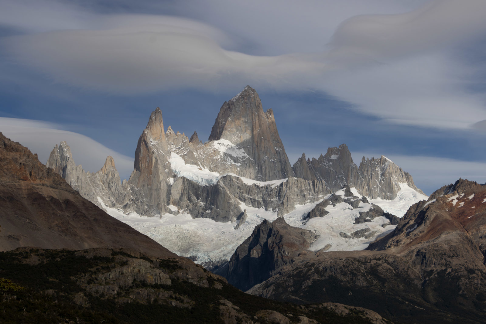Close view of the granite towers of Fitz Roy from Mirador Fitz Roy, with glaciers and lenticular clouds above the Patagonian mountains.