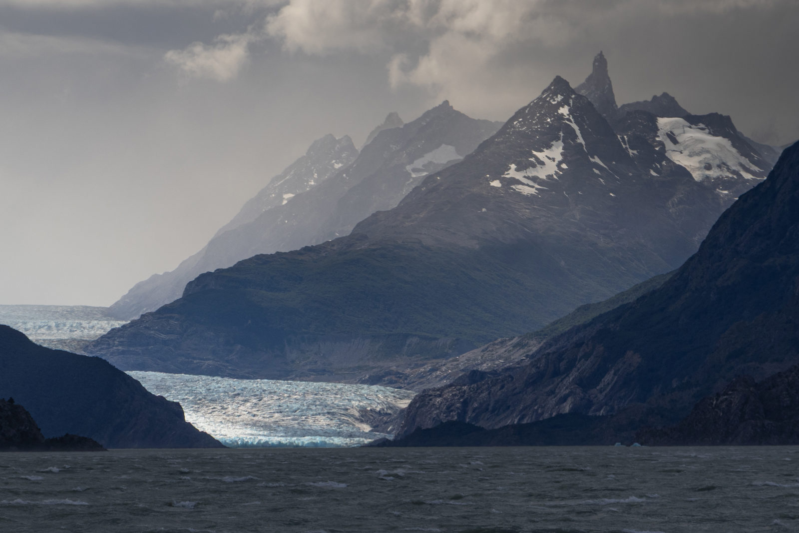 Late‑afternoon stormy skies over the distant Grey Glacier, seen about 3km away across Lago Grey in bitterly cold, windy Patagonian weather.