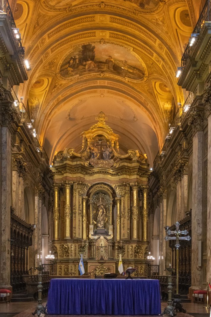 Ornate interior of Catedral Metropolitana de Buenos Aires with the main altar and vaulted ceiling.
