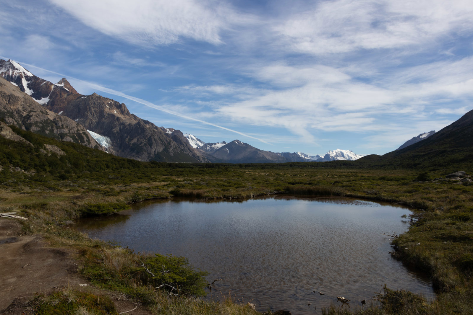 View across the open plateau on the Fitz Roy trail towards Glaciar Piedras Blancas, with a small lake, lenga woodland and mountains near El Chaltén.