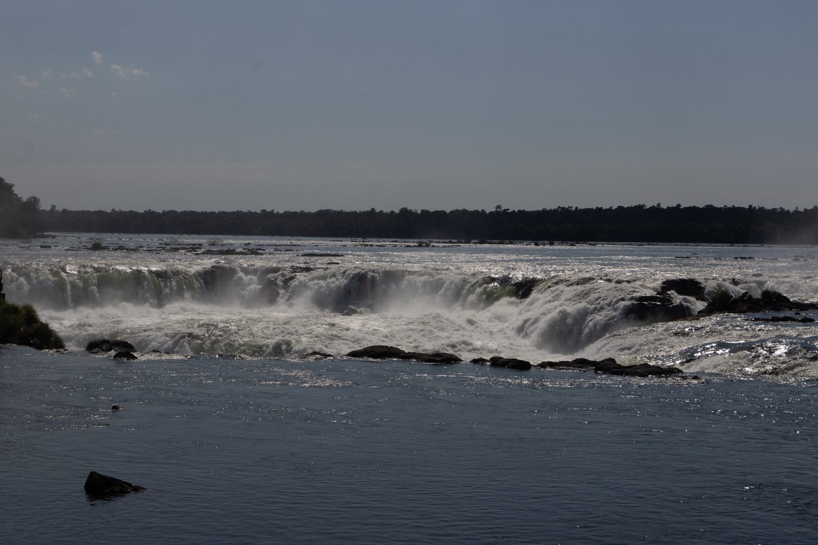 Water from the Upper Iguazú River plunging over Devil's Throat at Iguazú Falls in Argentina, creating spray and mist.