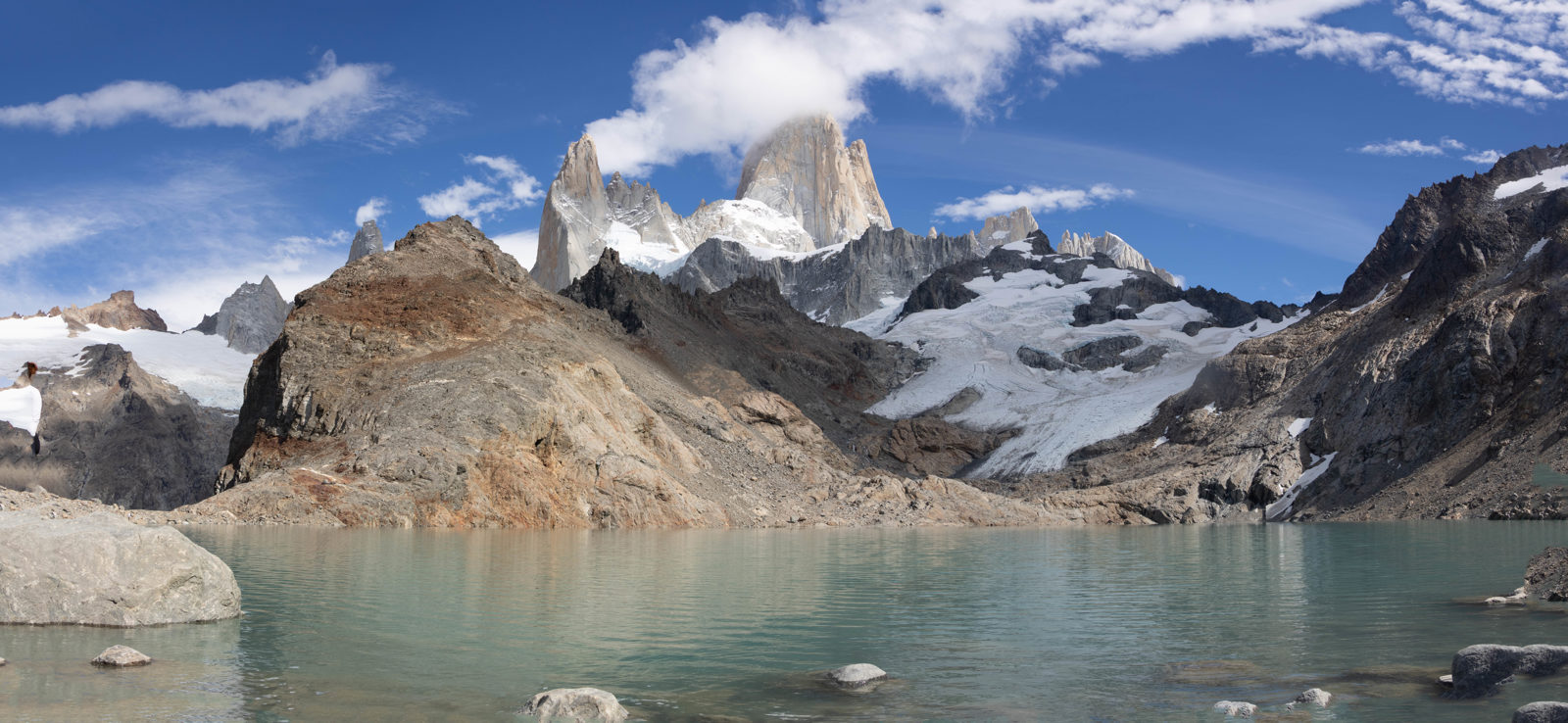 Panoramic view of Laguna de los Tres with Fitz Roy, surrounding granite towers and glaciers reflected in the turquoise water.