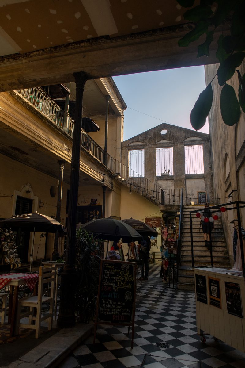 Entrance to a restored nineteenth-century courtyard in San Telmo, Buenos Aires, with cafés, artisan shops and a central staircase.