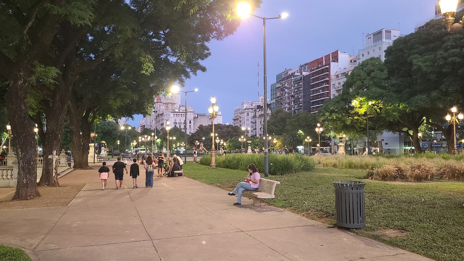 Evening view of Plaza del Congreso in Buenos Aires with people walking through the gardens.