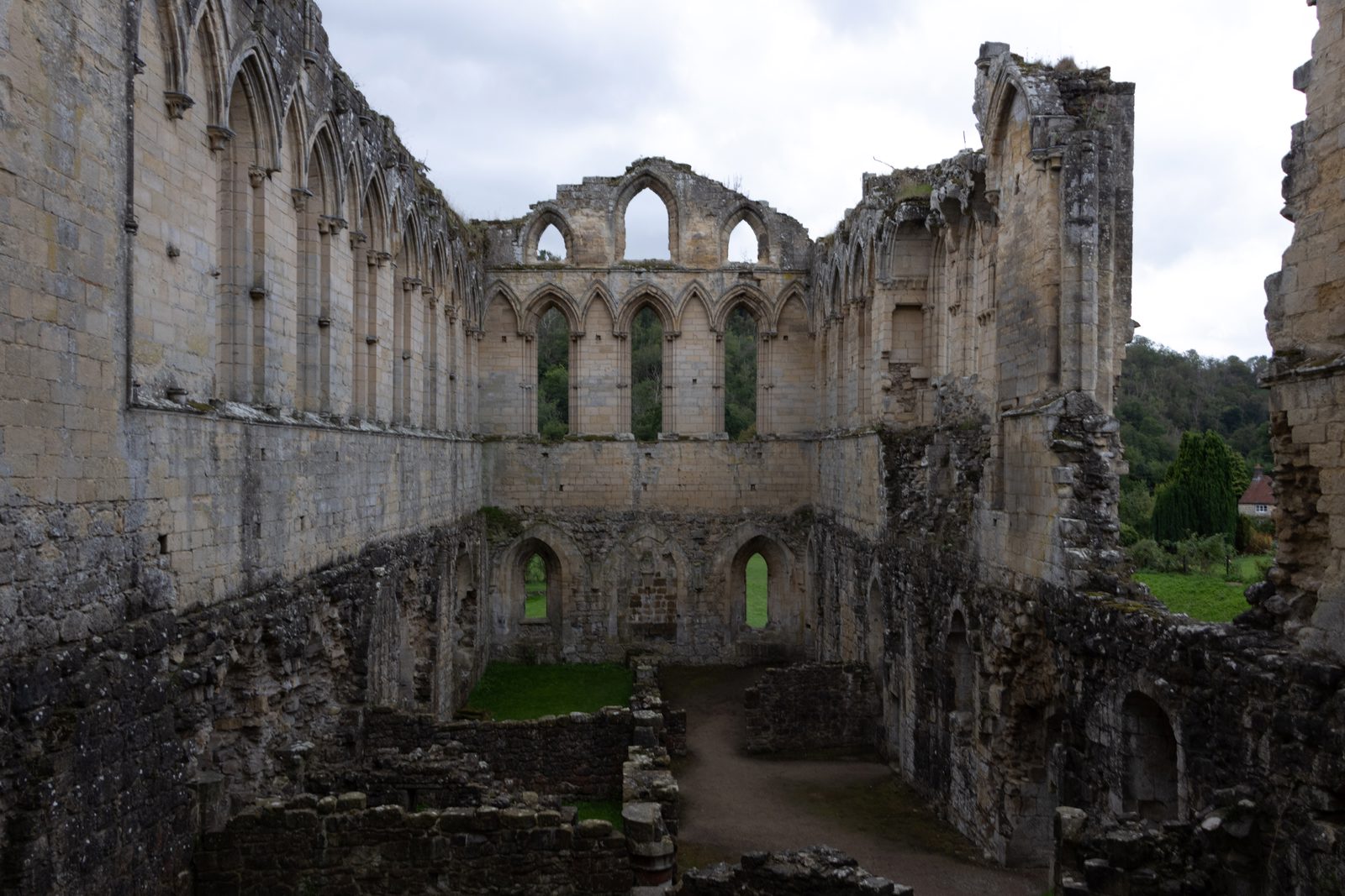 Interior ruins with tall stone walls and windows at Rievaulx Abbey