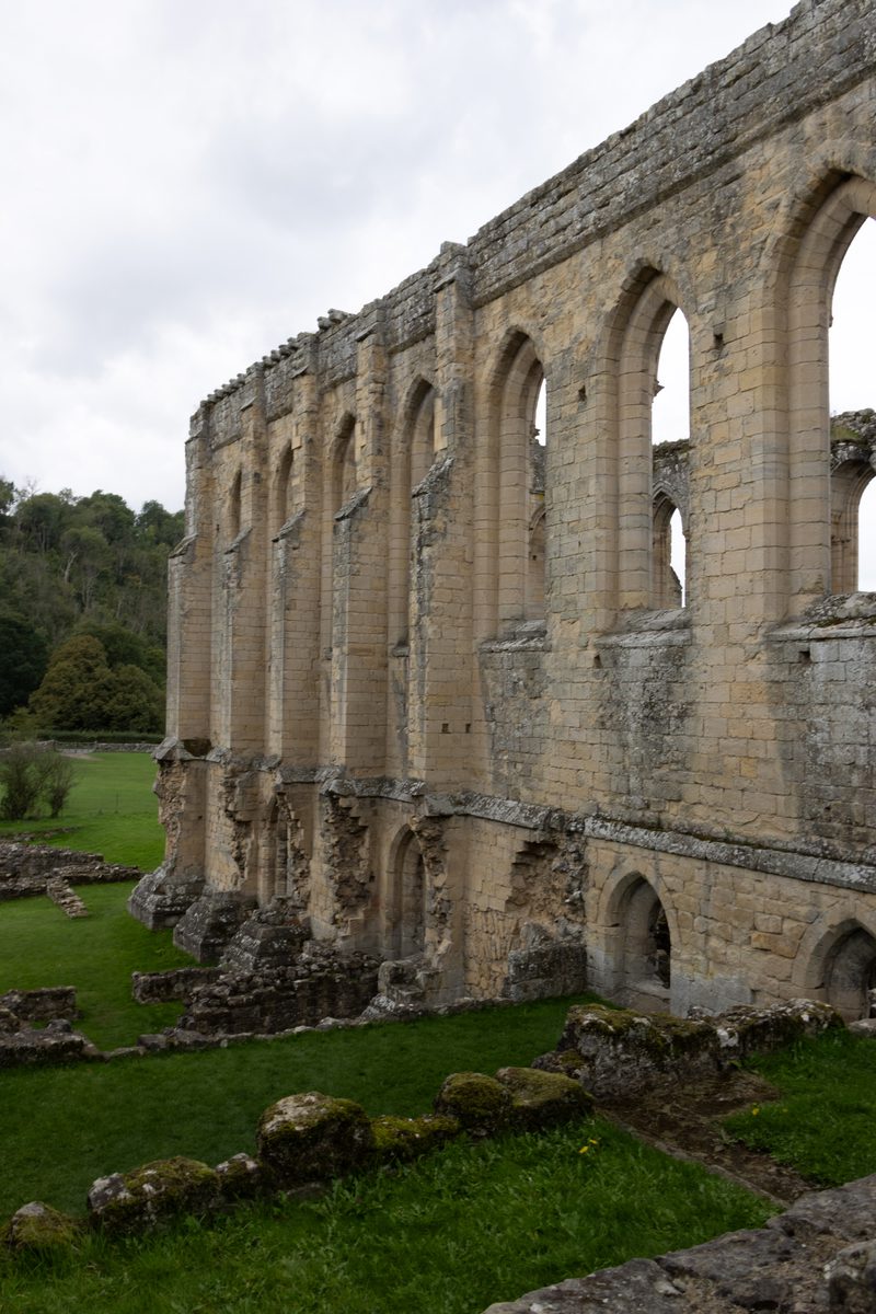 Long ruined wall with a row of tall arches at Rievaulx Abbey
