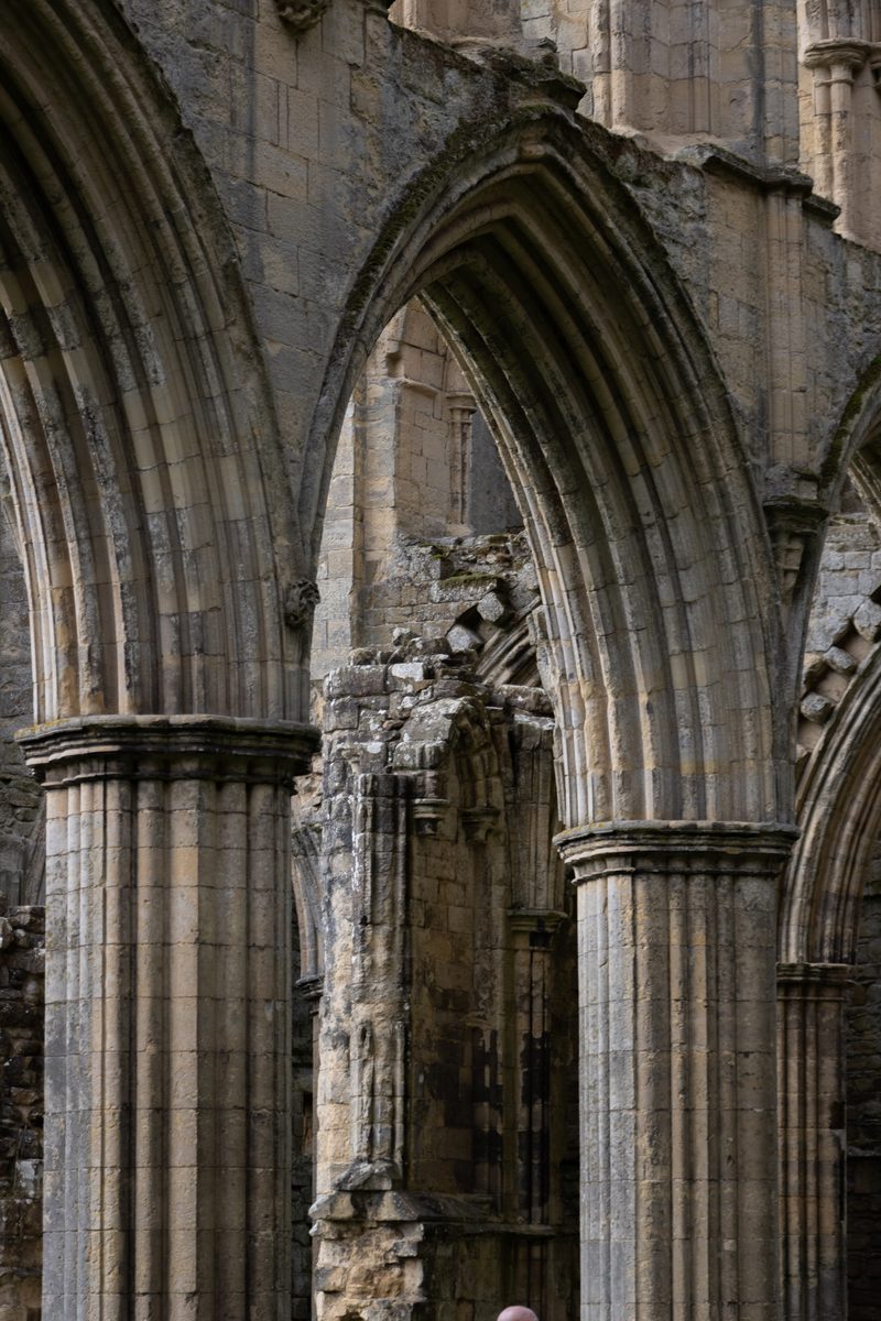 Close view of a pointed stone arch and columns at Rievaulx Abbey