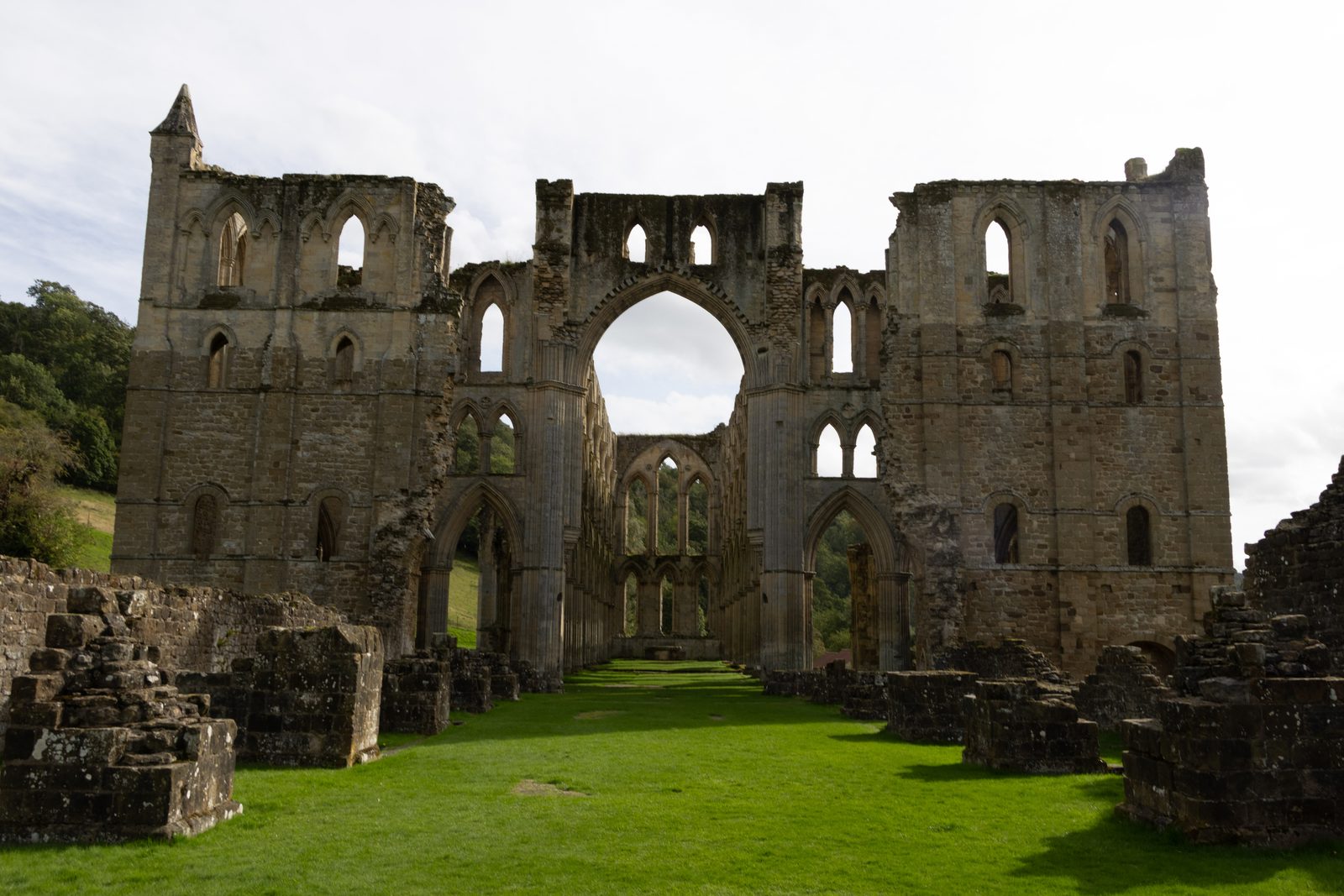 Ruined stone wall with a central arched opening at Rievaulx Abbey